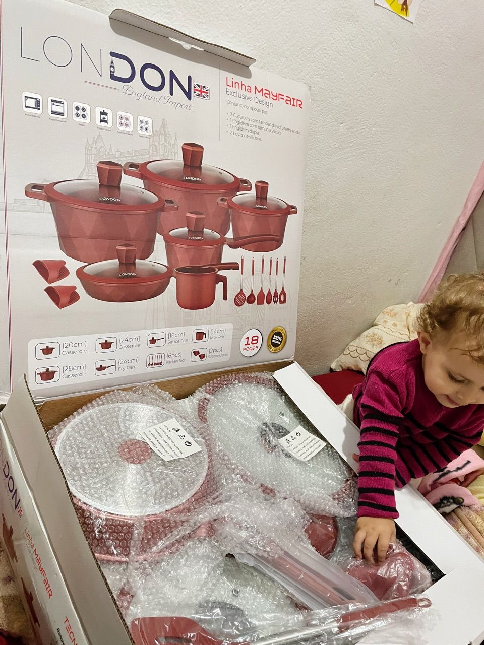 Cliente a abrir a caixa do kit 18 peças com a filha